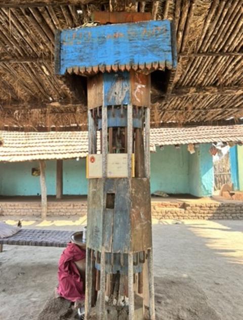 Carved wooden pillar in a village courtyard