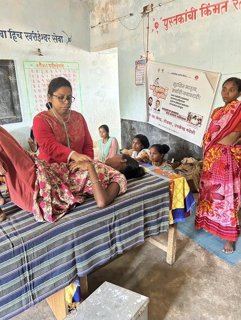 Doctor examining a patient at a village health camp