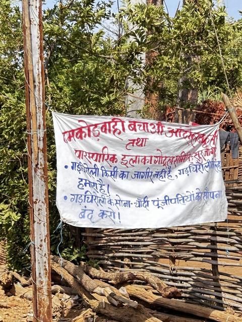 Hand-painted protest banner tied to a fence