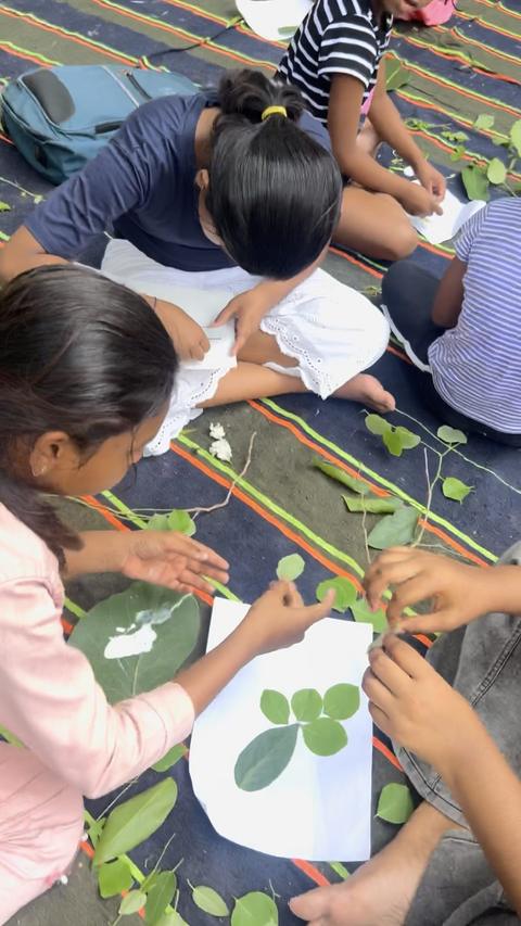 Children making leaf art on paper