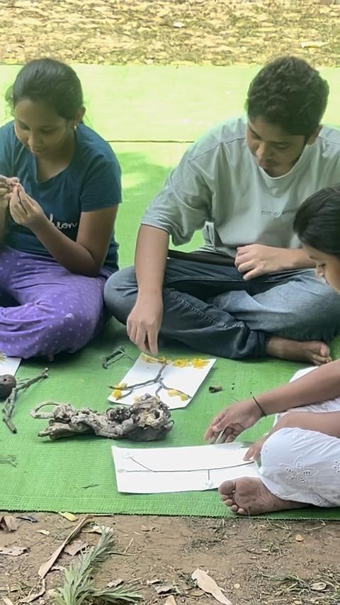 Children doing a nature craft activity on a green mat