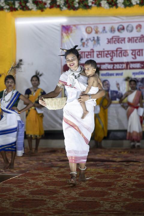 Woman in traditional dress carrying a child and basket on the ramp